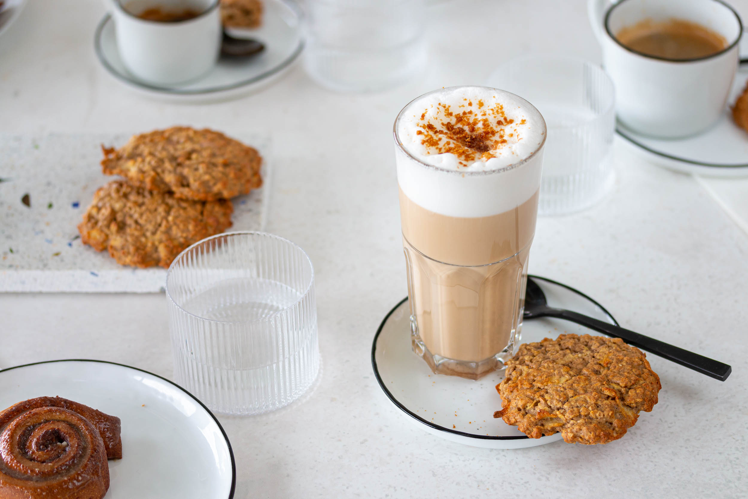 Good Jul Latte Kaffee mit einem Haferguetzli auf einem Tisch