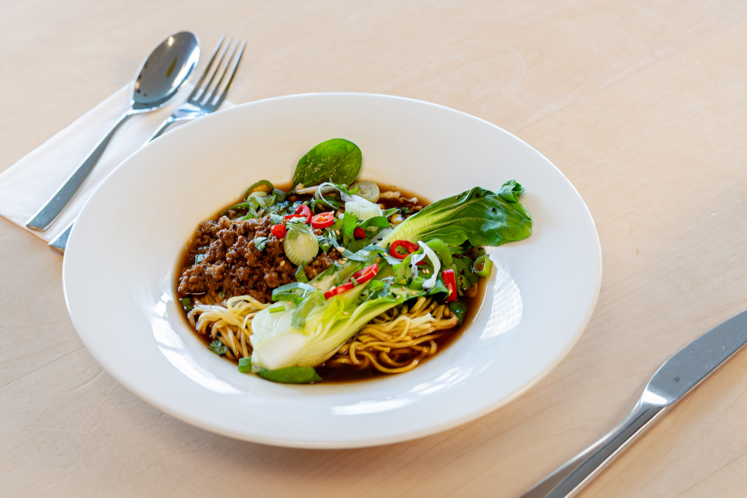 Vegane Ramen-Suppe mit Pak-Choi, Mais, Frühlingszwiebeln und pflanzenbasiertem Hack.