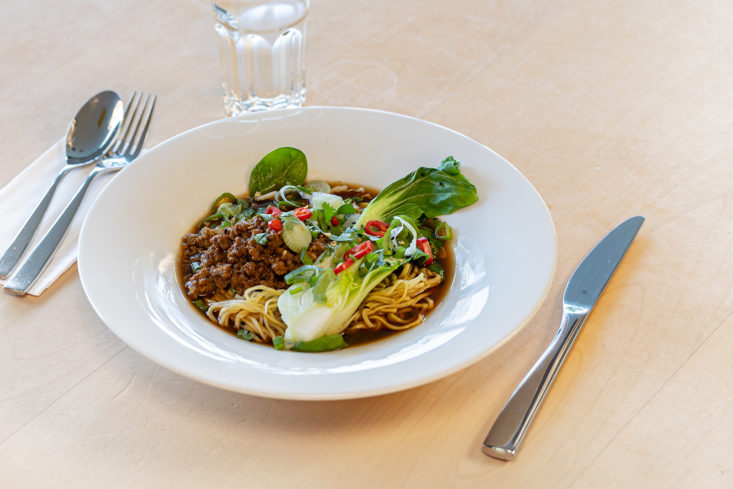 Vegane Ramen-Suppe mit Sesam-Miso Brühe, Pak-Choi, Mais, Frühlingszwiebeln und pflanzenbasiertem Hack