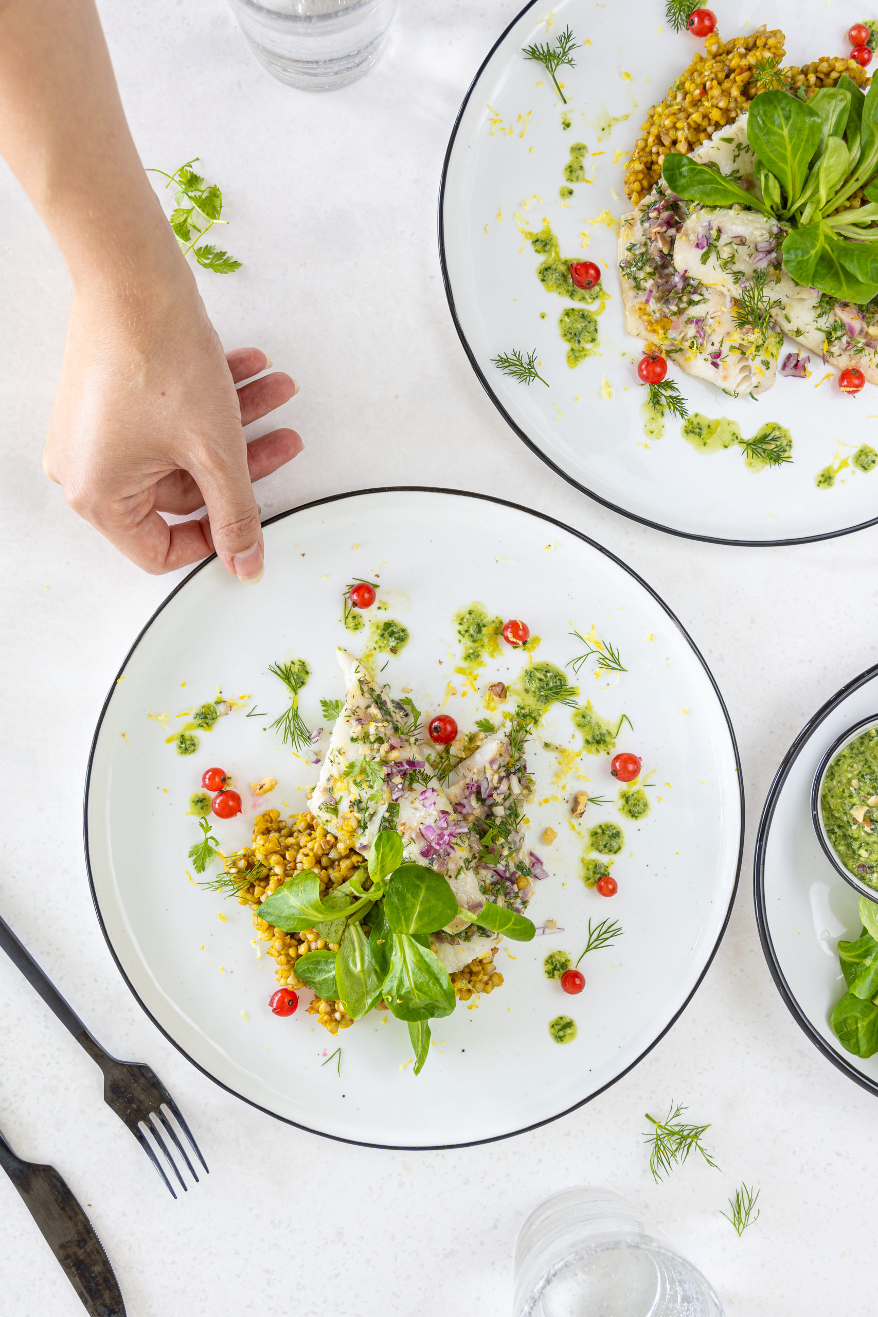 Zart gebratenes Zanderfilet mit frischer Dill-Kräutermarinade, serviert auf cremigem Nüsslisalat-Baumnusspesto und begleitet von goldgelbem Safran-Buchweizen.