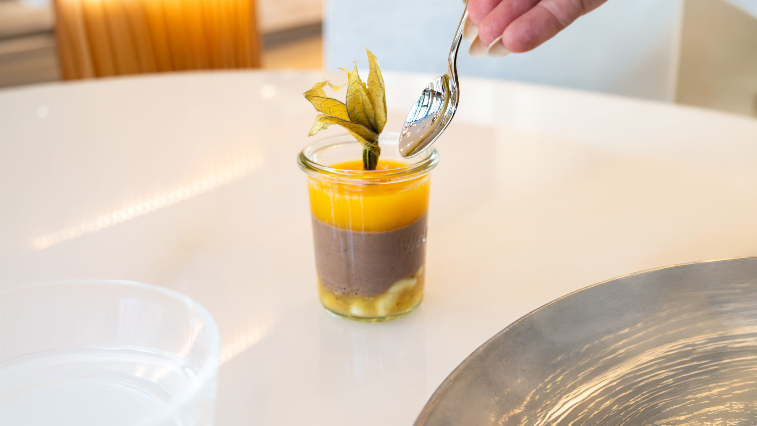 Fair Trade Schokoladencrème mit Bananen und Passionsfruchtcoulis aus saubererem weissen Tisch